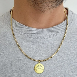 Golden box chain necklace featuring a heart hands gesture pendant worn by a model