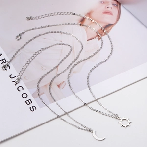 Minimalist silver sun and moon pendant necklace set in polished stainless steel