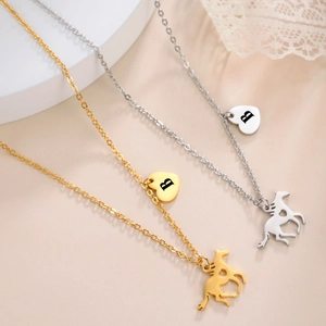 Detail of gold and silver horse necklaces with heart pendants and letter B engraving