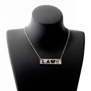 Detail of silver steel necklace featuring a cowboy-themed LOVE pendant on a black bust