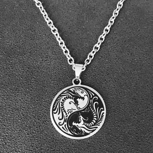 Gros plan du pendentif dragon yin yang noir et argent sur une chaîne en acier