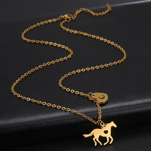 Detailed macro view of gold-plated stainless steel horse pendant with hollow heart cutout
