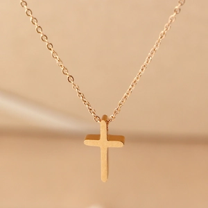 Minimalist gold titanium steel cross necklace with a brushed finish on a delicate O-chain
