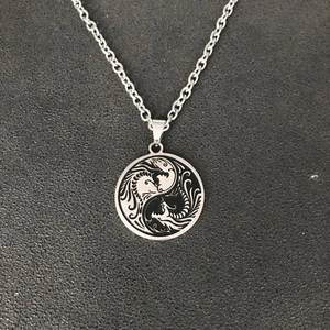 Collier pendentif double dragon yin yang en acier inoxydable argenté sur fond gris