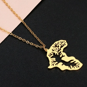 Gros plan du pendentif doré carte de Sierra Leone avec texture de l'arbre de vie creuse