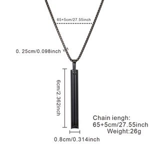 Matte black stainless steel meditation whistle pendant with dimensions shown on white background