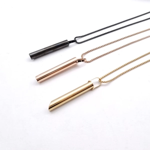 Primer plano de collares de respiración cilíndricos en negro, oro rosa y oro con cadenas box