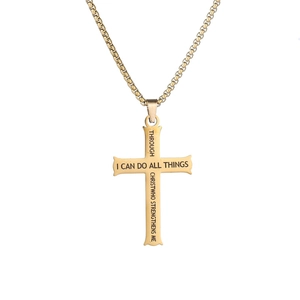 Détail macro du pendentif croix en acier doré avec gravure laser d'un verset biblique