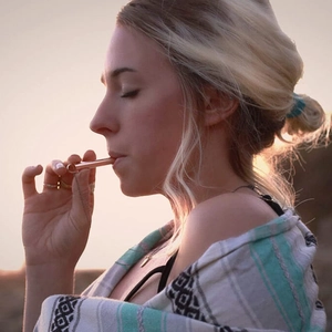 Primer plano de mujer usando collar de meditación en oro rosa al atardecer