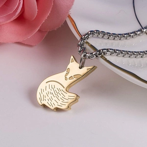 Vue macro d'un pendentif renard doré sur chaîne argentée avec fond floral en céramique