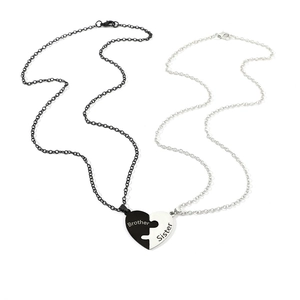 Detail of Brother and Sister puzzle heart pendants in black and silver finishes