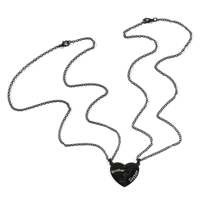 Detail of interlocking black heart pendant set with white Brother and Sister lettering