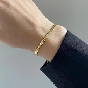 Minimalist gold snake chain bracelet in titanium steel for men and women on a wrist