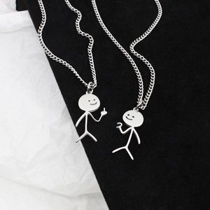 Macro shot of matching silver stickman heart pendants on contrasting black and white textures