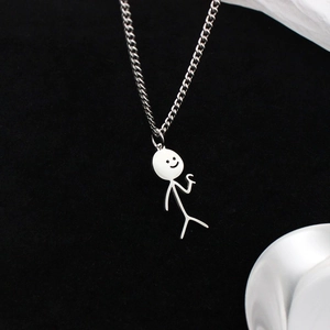 Detail of white stickman pendant with smiling face on a silver metal chain necklace