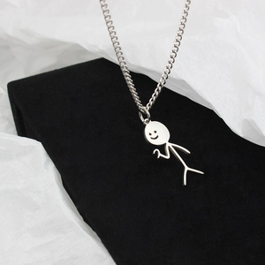 Macro shot of a funny stickman pendant necklace in silver stainless steel on velvet