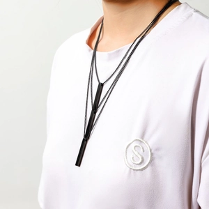Collier multicouche en acier inoxydable noir avec pendentifs géométriques sur un mannequin