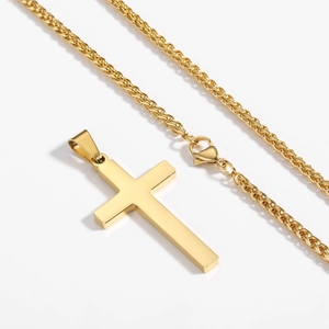 Vue détaillée du pendentif croix en acier doré avec chaîne épi et fermoir mousqueton robuste