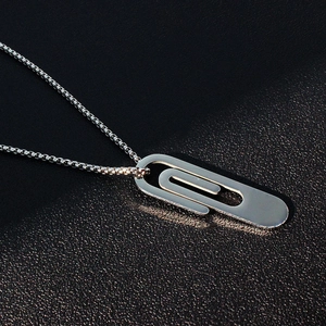 Macro shot of polished stainless steel paperclip pendant with fine round box chain link