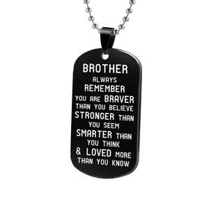 Macro shot of black stainless steel dog tag necklace with engraved brother quote