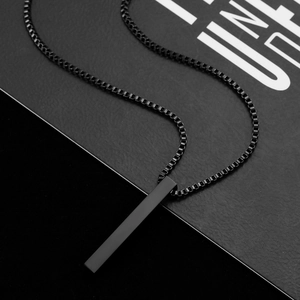 Detailed view of a matte black cylindrical pendant with a stainless steel box chain