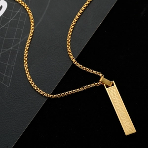 Detailed close-up of rectangular gold pendant with Roman numerals on a box chain
