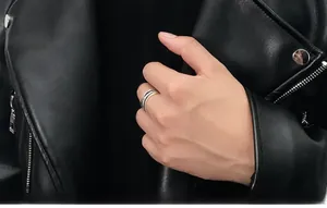 Détail d'une bague multicouche argent et noir portée avec une veste en cuir noir