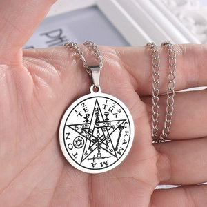Close-up of silver stainless steel Solomon Pentagram pendant necklace on a hand