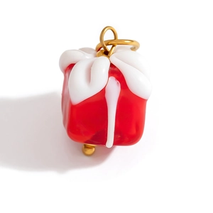 Macro shot of red glass Christmas gift box pendant with gold ring for DIY jewelry making