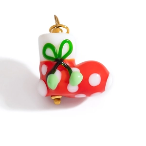 Détail du pendentif de botte de Noël en verre rouge avec des pois blancs