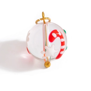 Macro shot of glass Christmas charm with candy cane and snowflake elements inside