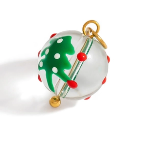 Vue macro d'un pendentif boule de Noël en verre avec sapin vert et motifs à pois rouges