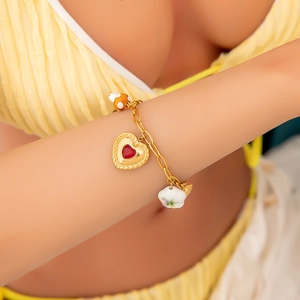 Goldenes Gliederkette-Armband mit Herz, Blume und Pilz-Anhängern am Handgelenk