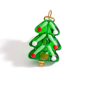 Detailed view of a green glass Christmas tree pendant with colorful polka dots and gold ring