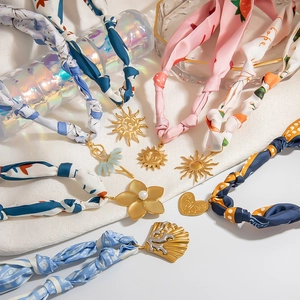 Elegant silk scarf necklace with gold stainless steel pendants and artistic floral patterns