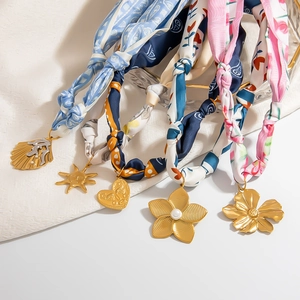 Artistic silk scarf necklaces with gold-toned charms including shell, sun, heart and floral
