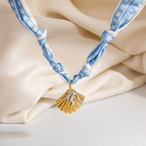Detail of nautical silk scarf necklace featuring shell pendant with pearl on satin