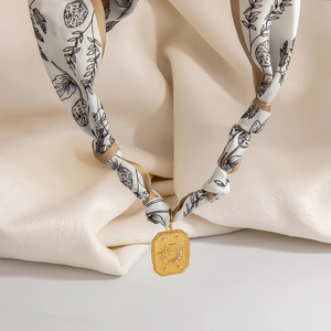 Dettaglio collana foulard in seta con pendente ottagonale dorato stella e luna