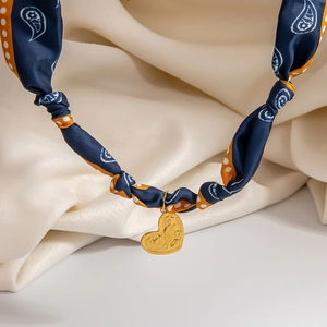 Detail of blue and orange paisley silk scarf necklace with a golden heart-shaped pendant