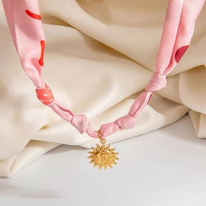Pink satin silk scarf necklace with a golden sun pendant in elegant V-shape style