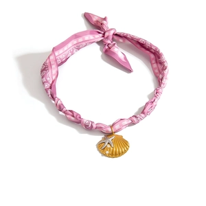 Detail der rosa Seidenschalkette mit goldenem Muschel- und silbernem Seesternanhänger