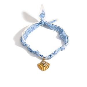 Close-up of silk scarf necklace with golden shell pendant and coral silver inlay
