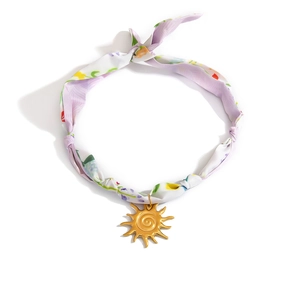 Detail eines Seiden-Chokers mit Blumenmuster, Sonnenanhänger und Knoten-Akzenten
