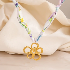 Collar de bufanda en tela floral con un colgante de flor dorada martillada