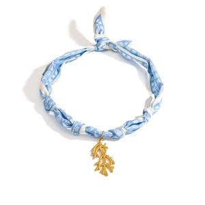 Detalle del colgante de rama de coral dorado con collar de bufanda de seda azul claro