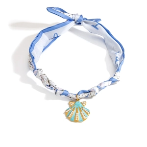 Detalle del collar de pañuelo de seda con colgante de concha azul, perlas y lazo elegante