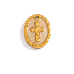 Detail of an oval 18K gold pendant featuring a cross relief and hammered texture frame