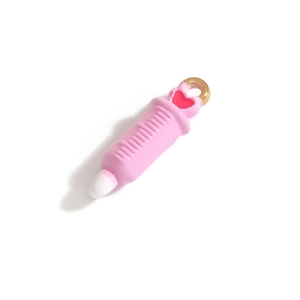 Détail de la breloque en forme de seringue rose avec cœur rouge et anneau doré