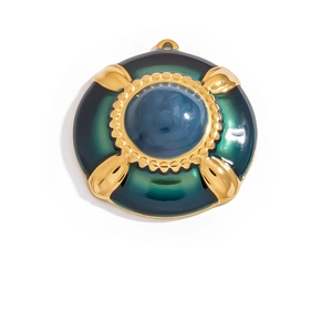 Macro shot of vintage round 18K gold pendant with deep green enamel and blue resin center