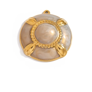 Macro shot of vintage round gold pendant with cream resin center and beaded edge detail